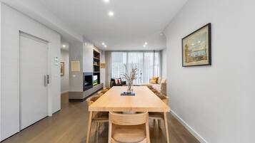 A modern living room with a dining table, sofas, and a fireplace.