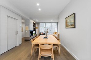 Ein modernes Wohnzimmer mit Esstisch, Sofas und Kamin.