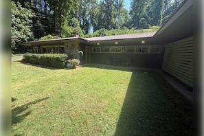 A building with a flat roof, a covered patio area, and a well-maintained lawn. - Mountain Memories Gatlinburg Home Sleeps 9 NO Winding Roads (Gatlinburg)