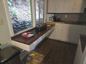 A kitchen with a window, a coffee maker, and a dish rack. - Mountain Memories Gatlinburg Home Sleeps 9 NO Winding Roads (Gatlinburg)