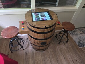 A wooden barrel-shaped bar with a digital screen, two stools, and a control panel with buttons. - Mountain Memories Gatlinburg Home Sleeps 9 NO Winding Roads (Gatlinburg)