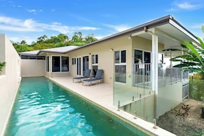 A modern house with a swimming pool, glass doors, and a covered patio area. - Tranquillity - Poolside Sanctuary & Rainforest Views (Smithfield)