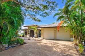 A residential property with a paved driveway, a garage, and a garden with tropical plants. - Tranquillity - Poolside Sanctuary & Rainforest Views (Smithfield)