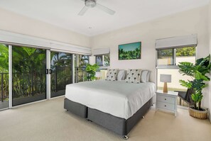 A bedroom with a bed, a desk, a chair, a ceiling fan, and a large window. - Tranquillity - Poolside Sanctuary & Rainforest Views (Smithfield)