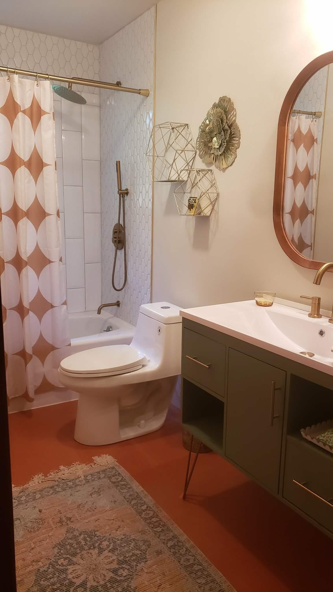 A bathroom with a shower, toilet, sink, and a mirror.