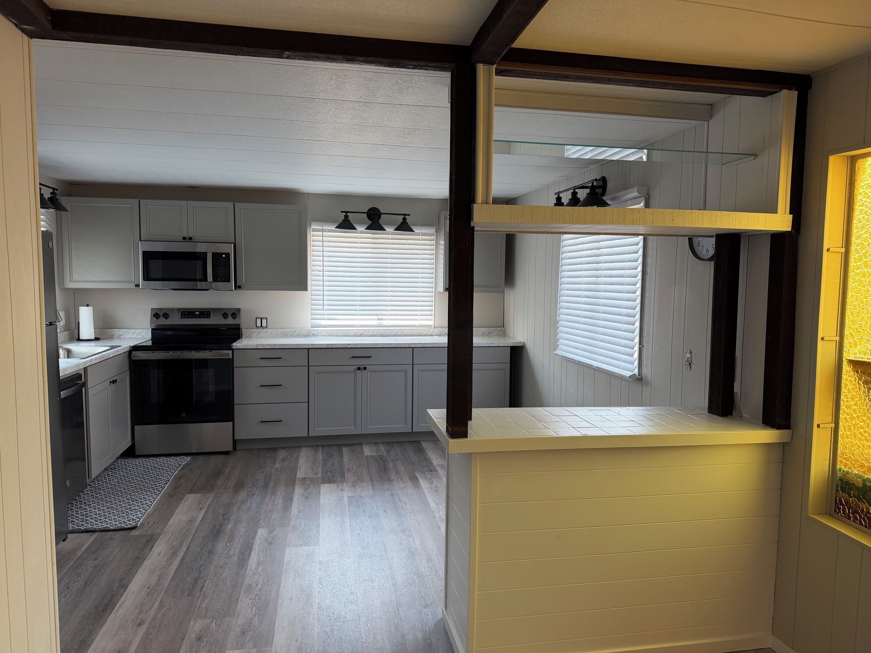 A compact kitchen with a microwave, stove, and cabinets.