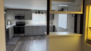 A compact kitchen with a microwave, stove, and cabinets.