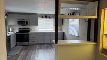 A compact kitchen with a microwave, stove, and cabinets.