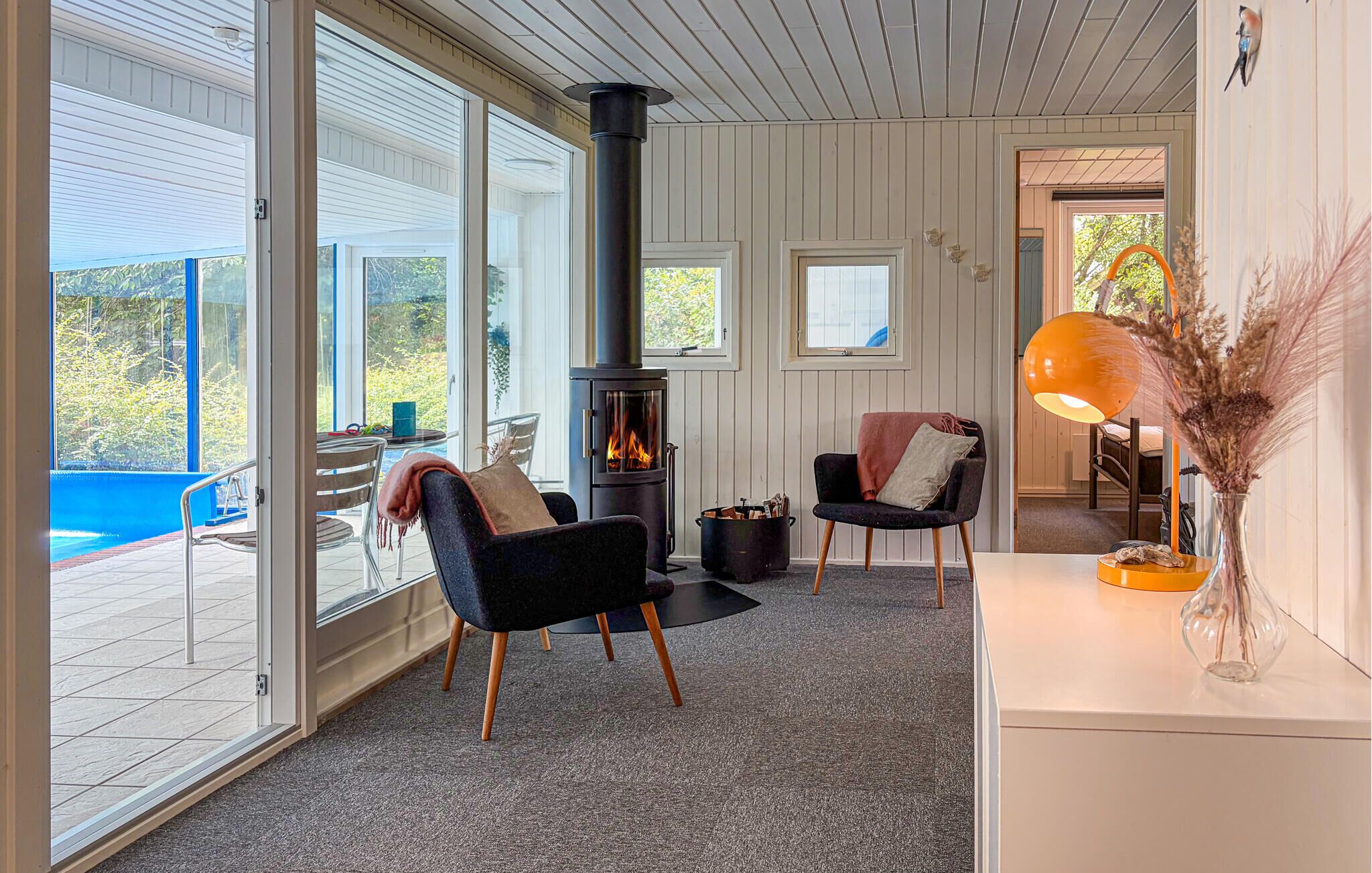 A cozy interior with a fireplace, seating area, and a view of the outdoors.