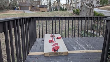 Une terrasse en bois avec une planche à l’arrière portant l’inscription « BACKYARD HERO™ » et un objet rouge posé dessus.