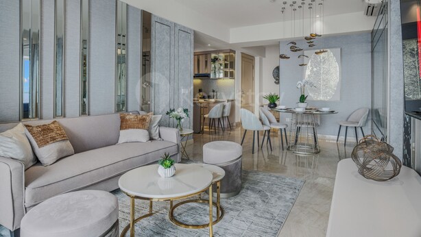 A modern living room with a sofa, coffee table, and chairs. There is a kitchen area in the background with cabinets and a dining table. - Ardana by Kozystay - Tunjungan (Surabaya)