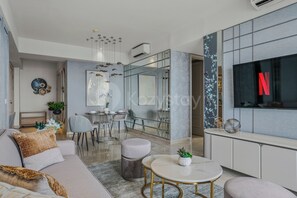 A modern living room with a sofa, coffee table, and dining area. - Ardana by Kozystay - Tunjungan (Surabaya)