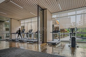 A gym with treadmills, a stationary bike, and a rowing machine. - Ardana by Kozystay - Tunjungan (Surabaya)