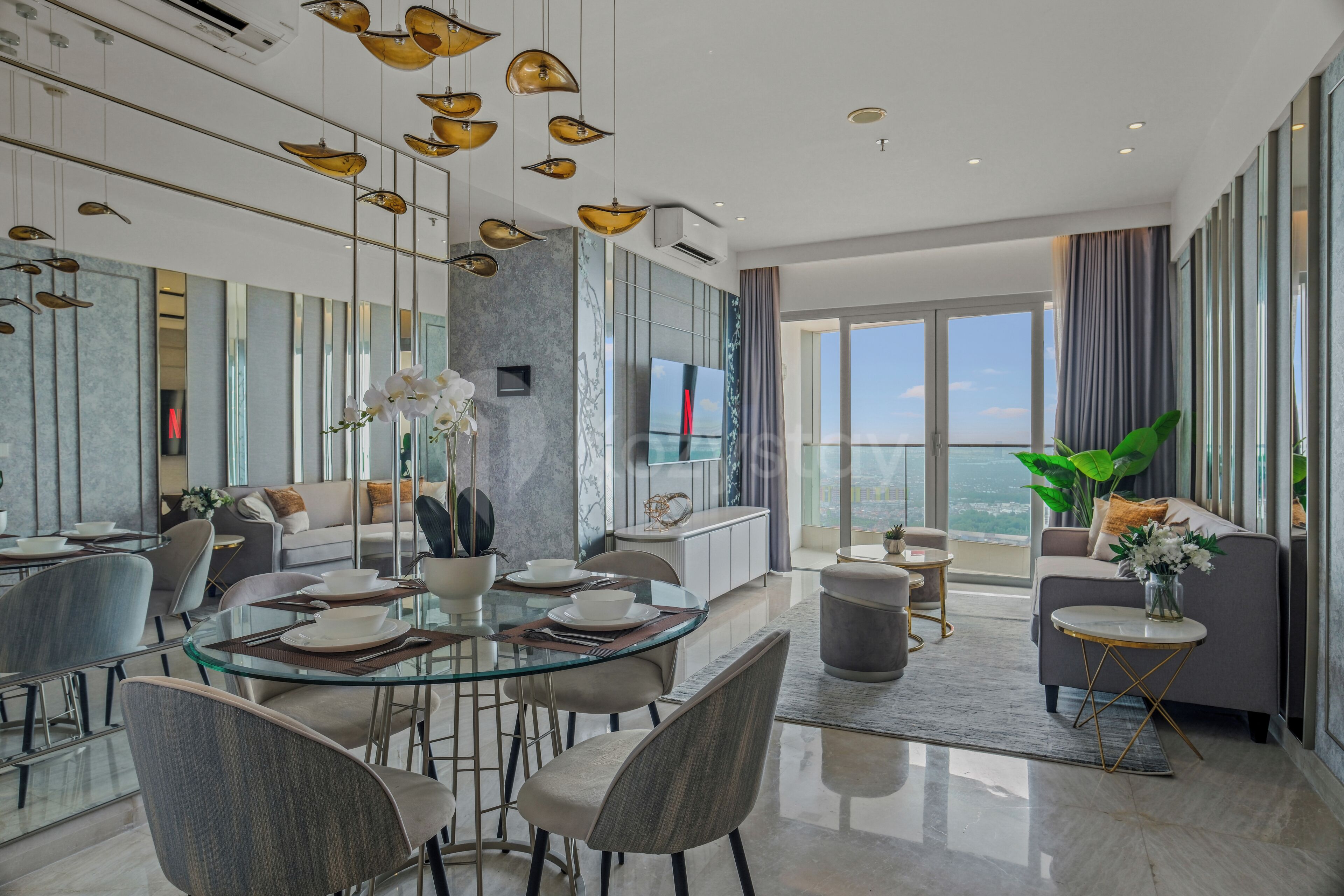 A modern dining area with a glass table, chairs, and a vase of flowers.