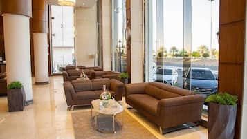 A modern lobby with a seating area, large windows, and a view of the street.