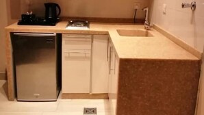 Una cocina compacta con refrigerador, lavavajillas y cafetera.