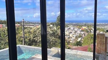 Una habitación con ventanas amplias que dan a una piscina y una zona residencial.