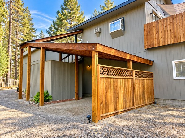 A house with a covered porch, a wooden fence, and a gravel driveway.