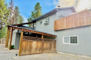 A two-story building with a covered porch and a fenced garage.