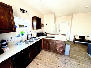 A modern kitchen with a dishwasher, double sink, and a microwave.