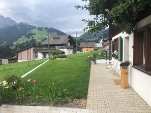 Ein Wohngebiet mit Häusern, einem gepflasterten Weg und einem Rasen.