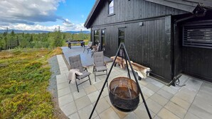 A wooden deck with outdoor furniture, a swing set, and a dog. - Gorgeous home in Vinje with WiFi (Vinje)