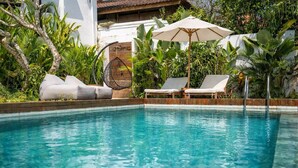 A swimming pool with lounge chairs and a hanging chair, surrounded by lush greenery. - Ubud's Best 2BR w Huge Rooftop & Pool by Ricefield (Ubud)