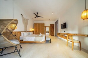 A modern bedroom with a bed, a wooden desk, a chair, a ceiling fan, and a television. - Hidden 3BR Oasis in Serene Ubud w Huge Pool+Patio (Gianyar Regency)