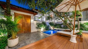 A pool area with a wooden deck, a lounge chair, and a wooden door. - Cozy 3BR in Ubud w Bathtubs, Ricefield Views, Pool (Tegallalang)