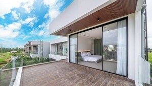 A modern house with a balcony, a bedroom with a bed, and a view of the countryside. - Luxe Jungle 4BR in the Heart of Ubud w Pool, Patio (Gianyar Regency)