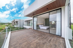 A modern house with a balcony, a bedroom with a bed, and a view of the countryside. - Luxe Jungle 4BR in the Heart of Ubud w Pool, Patio (Gianyar Regency)
