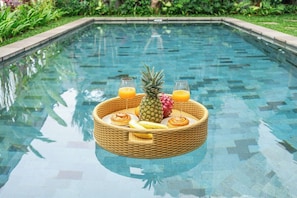 A pool with a floating basket containing fruits and drinks. - Luxe Jungle 4BR in the Heart of Ubud w Pool, Patio (Gianyar Regency)