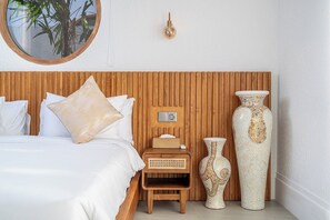 Une chambre à coucher avec une tête de lit en bois, une table de chevet avec une lampe et deux vases décoratifs.