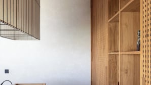 A corner of a room with a wooden desk, a chair, and a built-in wooden shelving unit. - ART1 - Designer Villa with 2 Bedrooms & Pool, Ubud (Gianyar Regency)
