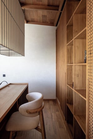 A corner of a room with a wooden desk, a chair, and a built-in wooden shelving unit. - ART1 - Designer Villa with 2 Bedrooms & Pool, Ubud (Gianyar Regency)
