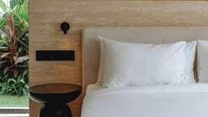 A bedroom with a bed, bedside table, and a wooden headboard. - Serene 2BR Villa in Ungasan- Close to Beach + Pool (Badung Regency)