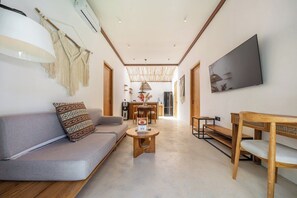 Ein modernes Wohnzimmer mit Sofa, Couchtisch und Holzmöbeln.