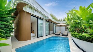 Uma área de piscina moderna com piscina azul cristalina, uma parede de madeira e uma porta de vidro que dá para um quarto.