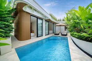 A modern pool area with a clear blue pool, a wooden wall, and a glass door leading to a room. - Designer 2BR in Ungasan w Pool & Beach Access (Badung Regency)