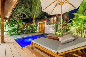 Ein Poolbereich mit Liegestühlen und einer Holzterrasse.