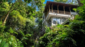 A modern building with a balcony, surrounded by dense tropical vegetation. - Jungle Villa, Brand New, Unique Art Design, Pool (Gianyar Regency)