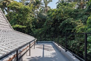 A rooftop terrace with a tiled roof, surrounded by dense tropical vegetation. - Jungle Villa, Brand New, Unique Art Design, Pool (Gianyar Regency)