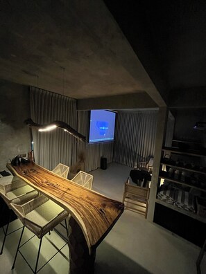 A modern interior with a wooden bar, seating, a television, and a staircase. - Jungle Villa, Brand New, Unique Art Design, Pool (Gianyar Regency)