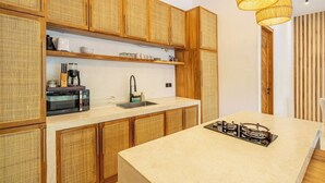 Eine Küche mit Holzschränken, einer Mikrowelle, einem Spülbecken und einem Gasherd.