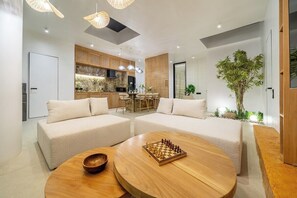 Ein modernes Wohnzimmer mit zwei Sofas, einem Couchtisch und einem Schachbrett.