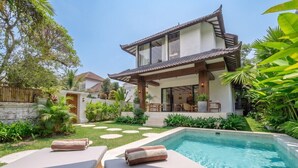 A modern house with a swimming pool, lounge chairs, and a well-maintained garden. - Designer 3BR Stay in Ubud • Pool • Patio • Garden (Gianyar Regency)