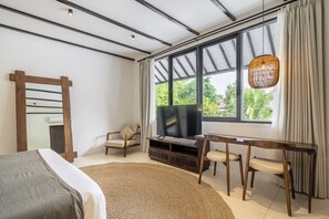Ein modernes Schlafzimmer mit einem Bett, einem Fernseher, einem Holzstuhl, einer Couch und einem großen Fenster mit Vorhängen.