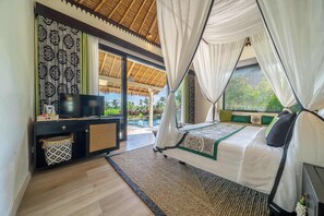 A bedroom with a bed, a TV, a desk, and a view of the outdoors. - Chic 2BR Villa in Serene Ubud w Pool+Patio+Garden (Gianyar Regency)