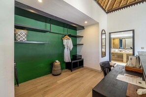 A modern interior with a green accent wall, wooden flooring, a black console table, and a mirror. - Chic 2BR Villa in Serene Ubud w Pool+Patio+Garden (Gianyar Regency)