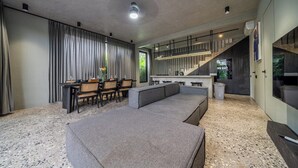 Een modern interieur met zithoek, keuken en trap.